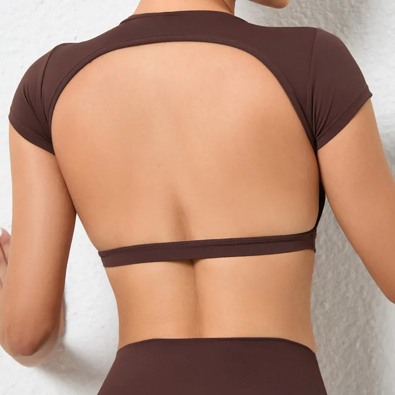 Woman wearing a backless workout crop top with breathable, stretchy fabric — perfect for running, gym workouts, cycling, and outdoor activities.
