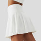 Woman wearing white high-waist skort with hidden pocket and built-in shorts