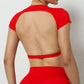 Woman wearing a red backless workout crop top with breathable, stretchy fabric — perfect for running, gym workouts, cycling, and outdoor activities.