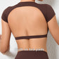 Woman wearing a backless workout crop top with breathable, stretchy fabric — perfect for running, gym workouts, cycling, and outdoor activities.