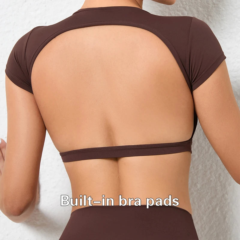 Woman wearing a backless workout crop top with breathable, stretchy fabric — perfect for running, gym workouts, cycling, and outdoor activities.