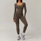 Woman wearing brown open-back summer jumpsuit with long sleeves and full-length legs.