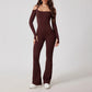 Woman wearing brown open-back summer jumpsuit with long sleeves and full-length legs.