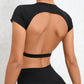 Woman wearing a black backless workout crop top with breathable, stretchy fabric — perfect for running, gym workouts, cycling, and outdoor activities.
