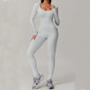 Woman wearing white open-back summer jumpsuit with long sleeves and full-length legs.
