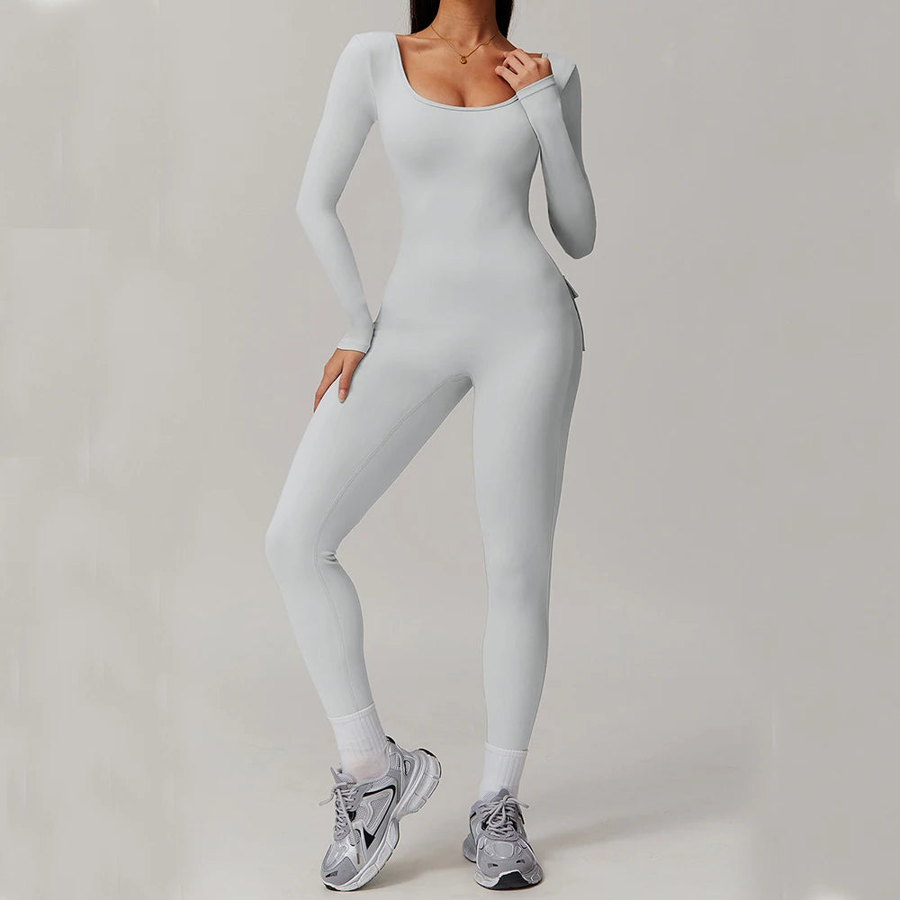 Woman wearing white open-back summer jumpsuit with long sleeves and full-length legs.