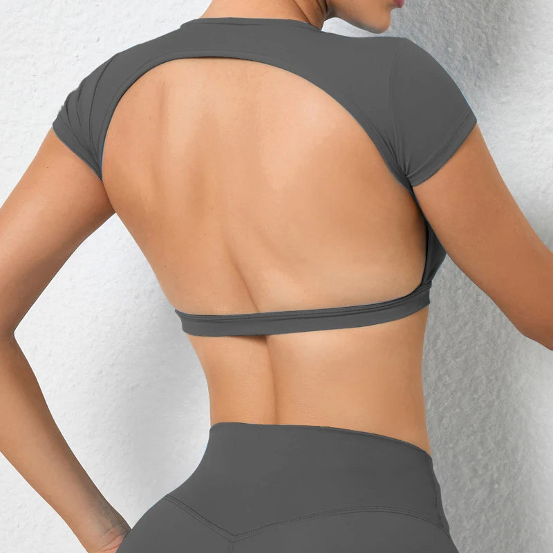 Woman wearing a backless workout crop top with breathable, stretchy fabric — perfect for running, gym workouts, cycling, and outdoor activities.