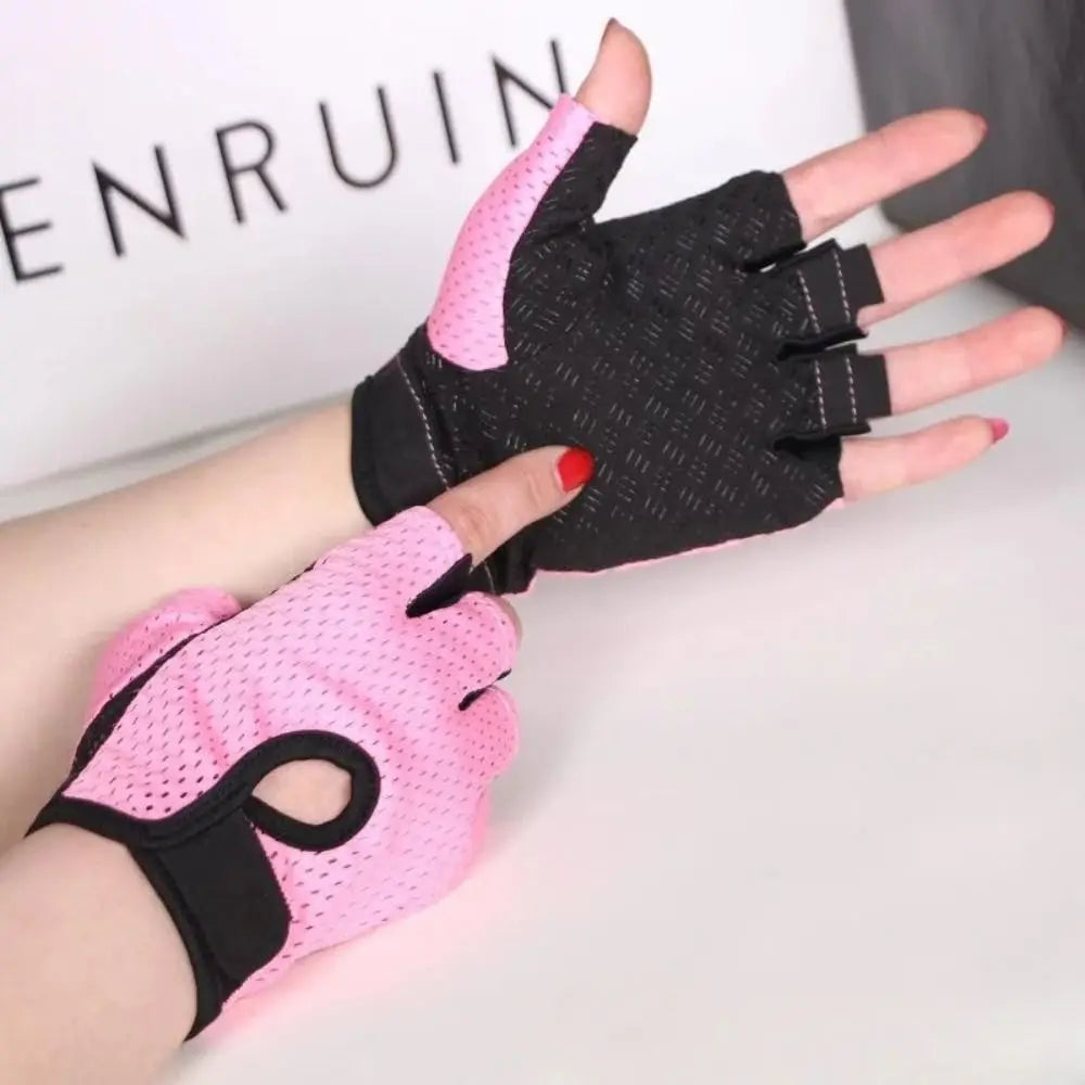 A pair of pink fingerless gloves being worn, designed for cycling with a focus on the gloves and part of the bike handle.