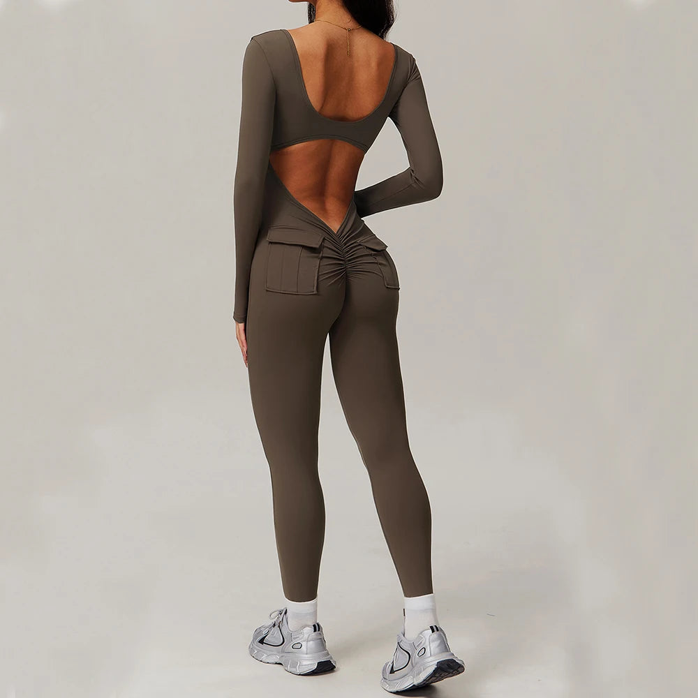 Woman wearing brown open-back summer jumpsuit with long sleeves and full-length legs.
