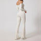 Woman wearing white open-back summer jumpsuit with long sleeves and full-length legs.
